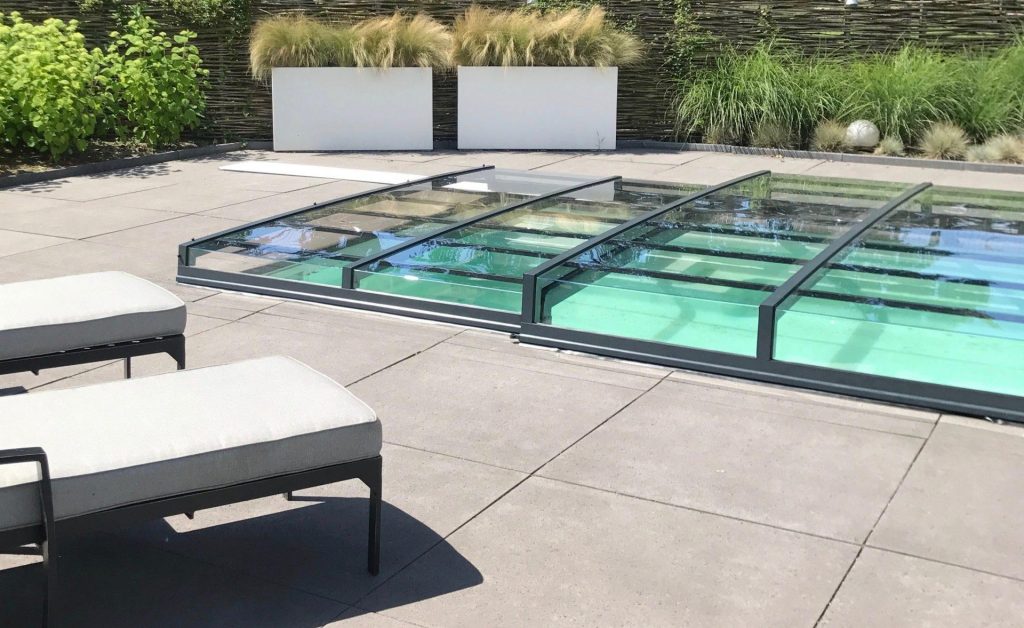 Luxe hoge zwembadoverkapping in moderne tuin met transparant dak en elegant design